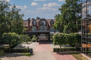 an exterior view of a building with trees in front at Hotel Heidegrund in Petersfeld