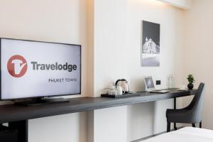 Travelodge Phuket Town في فوكيت تاون: تلفزيون بشاشة مسطحة جالس على طاولة في الغرفة