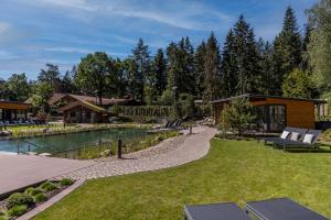 un patio trasero con piscina y una casa en Hotel Heidegrund en Petersfeld