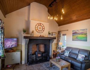 ein Wohnzimmer mit einem Sofa und einem Kamin in der Unterkunft The Cottages @ Slievenisky in Ballyward