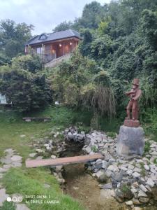 a garden with a statue and a house in the background at Domek nad chrząszczem in Szczebrzeszyn