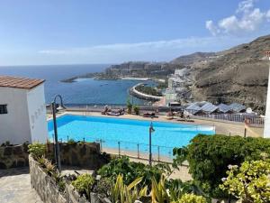 a swimming pool with a view of the ocean at Boho style bungalow with ocean view in Mogán