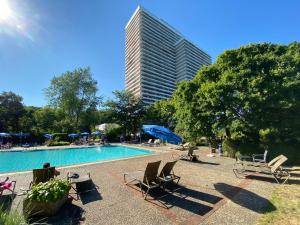 a swimming pool with chairs and a tall building at Timmendomizil - schöne Ferienwohnung in bester Lage - Sonnenseite in Timmendorfer Strand