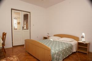 ein Schlafzimmer mit einem großen Bett und einer Tür in der Unterkunft Apartments by the sea Rogoznica - 4313 in Rogoznica