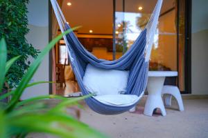 a blue hammock in a room with a table at Royal Cottage Residence in Lamai