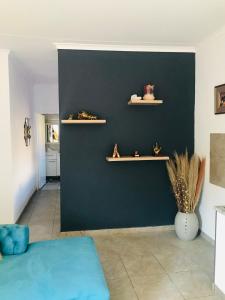 a living room with a blue wall with shelves at Shamrock Place in Roodepoort