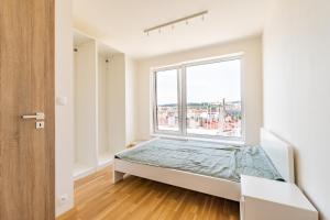 a bedroom with a bed and a large window at Penthouse # 81 with panoramic city view in Elite Rezidence with free parking in Prague