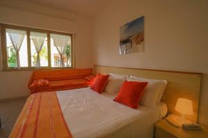 een slaapkamer met een groot bed met rode kussens bij Apulia Hotel Sellia Marina in Sellia Marina