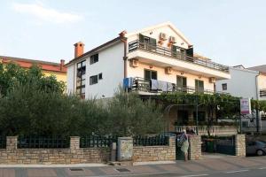 a person standing in front of a house at Apartments and rooms with parking space Vodice - 4164 in Vodice