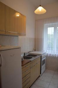 a kitchen with a white refrigerator and a sink at Apartments and rooms with parking space Vodice - 4164 in Vodice