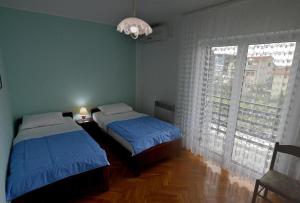 a bedroom with two beds and a large window at Apartments and rooms with parking space Vodice - 4164 in Vodice
