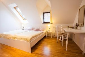 a bedroom with a bed and a desk and a window at House Trta in Ljubljana
