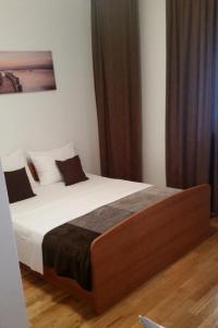 - une chambre avec un lit doté de draps blancs et d'oreillers bruns dans l'établissement Apartments by the sea Grebastica, Sibenik - 4254, à Šibenik