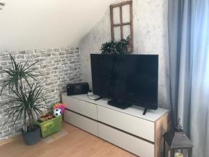 uma televisão de ecrã plano numa cómoda branca numa sala de estar em FeWoWe Ferienwohnung Wenden em Wenden