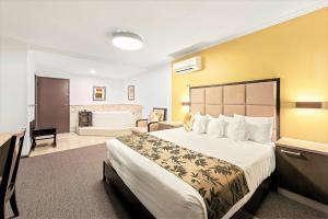 a hotel room with a bed and a bathroom at Eltham Gateway Hotel & Conference Centre in Eltham