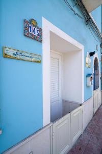 un edificio blu con una porta e un cartello sopra di La Casa di Nonna Piera a Giardini Naxos