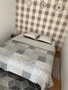 a bedroom with a bed with a checkered wall at Studio indépendant Lisieux in Lisieux