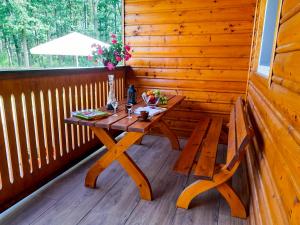 une table et un banc en bois dans une cabine avec fenêtre dans l'établissement Dom Wczasowy Smyk, à Biskupiec