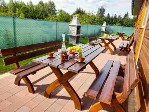 - une table de pique-nique et des bancs sur une terrasse dans l'établissement Dom Wczasowy Smyk, à Biskupiec