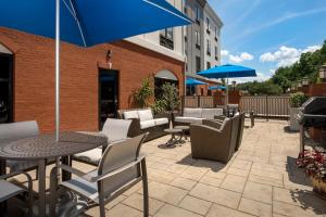 un patio al aire libre con sillas, mesas y sombrillas en Holiday Inn Express & Suites Knoxville-Clinton, an IHG Hotel, en Clinton