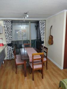 a dining room with a table and chairs and a guitar at Puerto Perales Talcahuano in Talcahuano