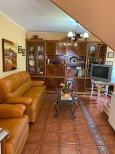 a living room with a couch and a television at Casa de campo en pleno centro de Asturias in Sesiello