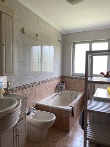 a bathroom with a tub and a toilet and a sink at Casa de campo en pleno centro de Asturias in Sesiello
