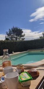 a table with food and drinks on it next to a swimming pool at Villa bellevue in Sillans-la Cascade