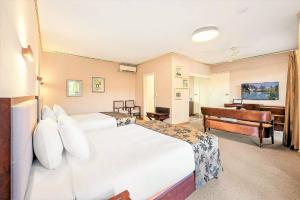 a hotel room with a large bed and a television at Eltham Gateway Hotel & Conference Centre in Eltham