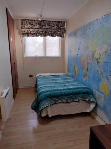a bedroom with a bed with a map on the wall at Puerto Perales Talcahuano in Talcahuano