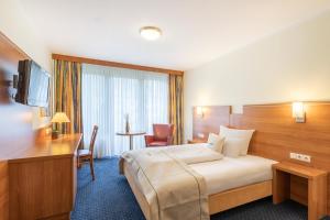 una camera d'albergo con letto e scrivania di acora Bochum Living the City a Bochum