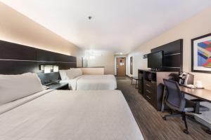 a hotel room with two beds and a desk at Holiday Inn Express London-I-70, an IHG Hotel in London