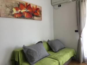 een groene bank in een kamer met een schilderij aan de muur bij Family-friendly apartments with swimming pool Dvornica, Rogoznica - 11470 in Rogoznica +24 foto's