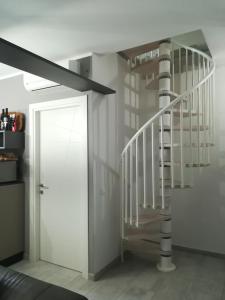 a white spiral staircase next to a white door at Aero Apartment in Elmas