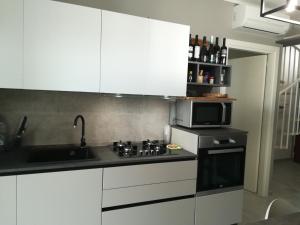 uma cozinha com um lavatório, um fogão e um micro-ondas em Aero Apartment em Elmas
