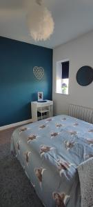 een slaapkamer met een groot bed met een blauwe muur bij Flat 7 Buxton Market Place Apartment in Buxton
