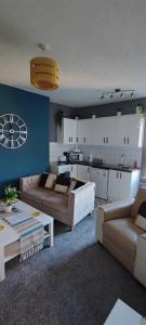 a living room with two couches and a kitchen at Flat 7 Buxton Market Place Apartment in Buxton