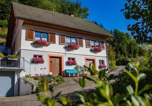 a white house with flower boxes on the windows at Haus Niedermättle in Oppenau