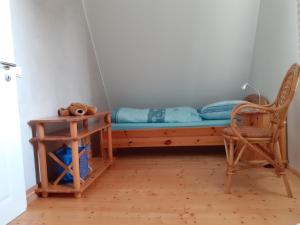Ce lit se trouve dans un dortoir doté d'une chaise et d'une table. dans l'établissement Ferienwohnung Erika, à Moritzburg