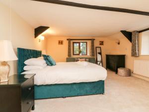 um quarto com uma cama grande e uma janela em The Thatched Cottage em Crediton
