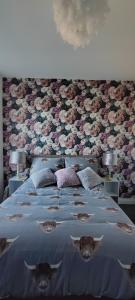 een slaapkamer met een groot bed met bloemen erop bij Flat 7 Buxton Market Place Apartment in Buxton