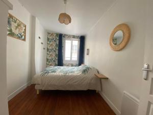 - une petite chambre avec un lit et un miroir dans l'établissement L'Abri-gîte - Appartement moderne idéalement situé en centre ville, à Dieppe