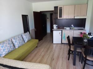 a living room with a couch and a table and a kitchen at Bansko All Seasons - Cozy Apartments Near Gondola & Mountain Views in Bansko