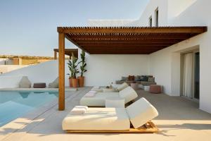 a living room with white furniture and a swimming pool at PAROCKS Luxury Hotel & Spa in Ambelas