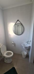 a bathroom with a toilet and a sink and a mirror at Cosy Cottage in Port Shepstone +11 photos