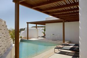 a villa with a swimming pool and a house at PAROCKS Luxury Hotel & Spa in Ambelas