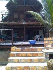 Casa Coco Palmeira في إنهامبان: منزل أمامه نخلة وسلالم