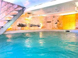 uma piscina interior com água azul em FABULEUX - Domaine du Moulin D'Andraut Bordeaux-Chevaux-Golf-St Emilion em Montussan