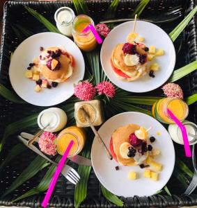 a table topped with plates of pancakes with fruit at Samui Boat Lagoon in Choeng Mon Beach