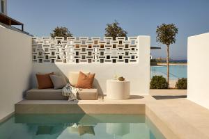 a living room with a couch next to a pool at PAROCKS Luxury Hotel & Spa in Ambelas